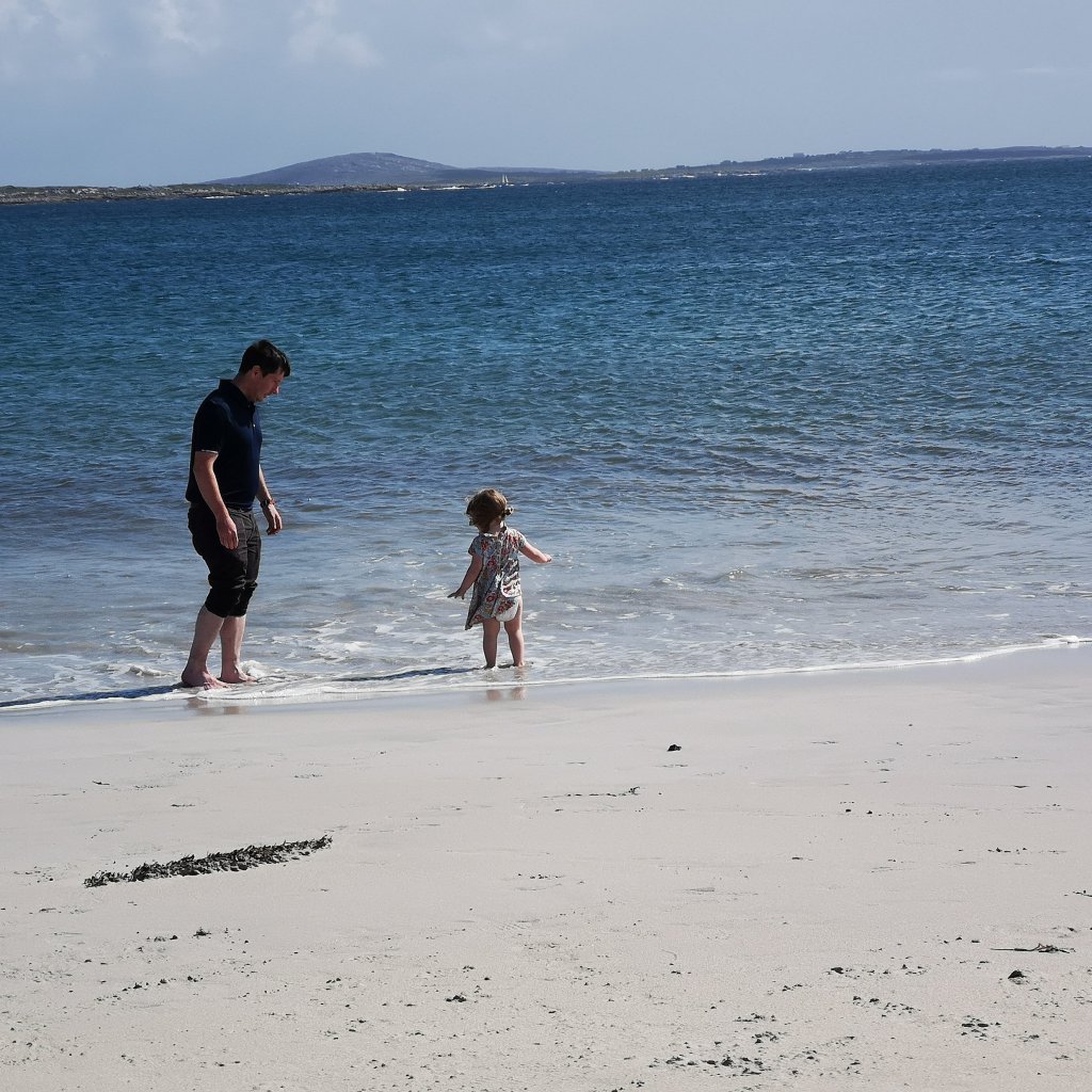 Daddy and toddler paddling in the sea